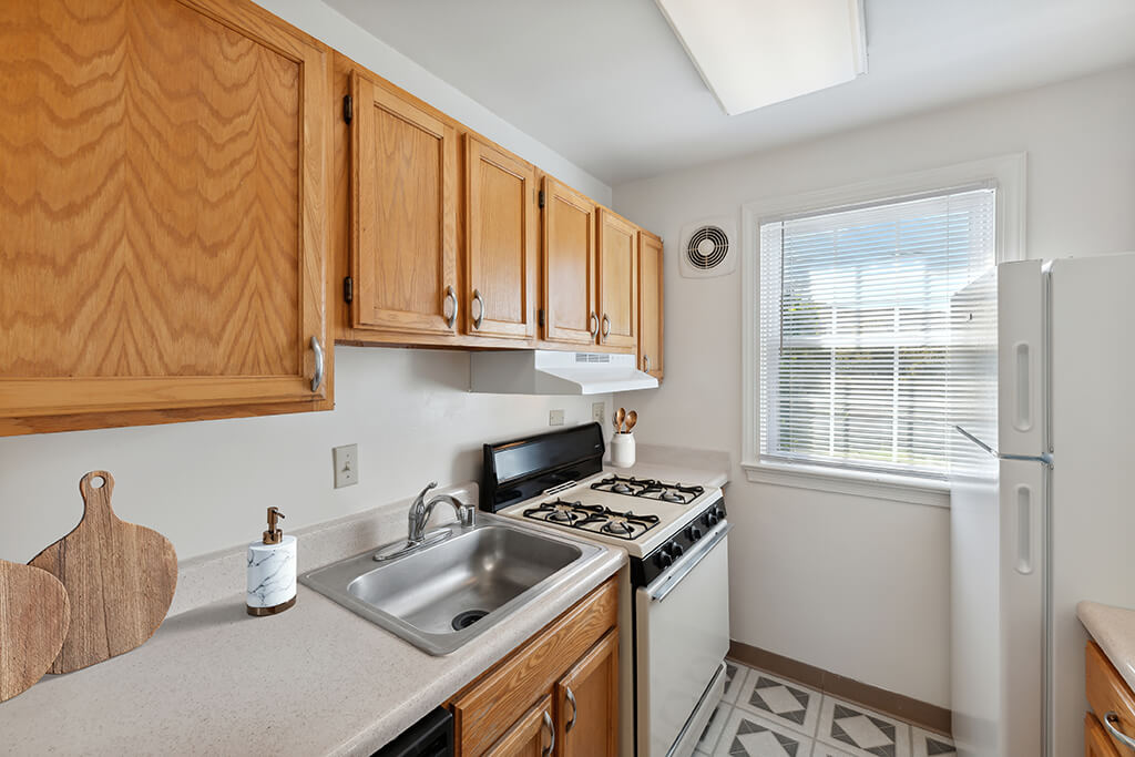 A kitchen with wooden cabinets and a white fridge.